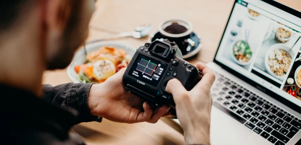 A man holding a camera looking at the settings.