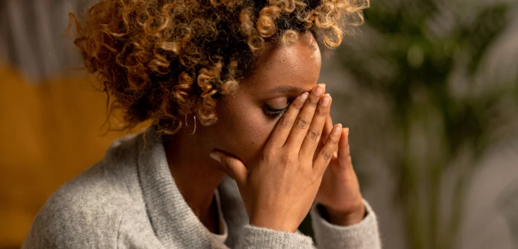 A lady with a lot of stress holding her head in her hands.