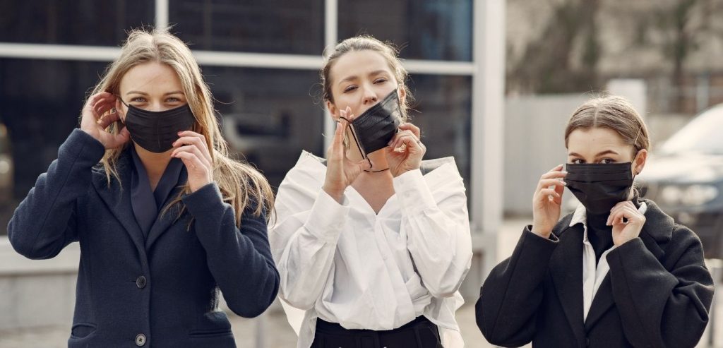 Three young ladies wearing masks.